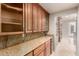 Kitchen features granite counters, wine cooler, glass front cabinets, and stone accents at 14494 W Yucatan St, Surprise, AZ 85379