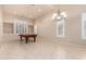 Brightly lit living room features plantation shutters, neutral walls, and chandelier over a billiards table at 14494 W Yucatan St, Surprise, AZ 85379
