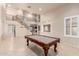 Spacious living area featuring a billiards table, staircase, large windows and neutral walls with tile flooring at 14494 W Yucatan St, Surprise, AZ 85379