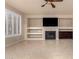 Living room features a fireplace, built-in shelves, tile flooring, plantation shutters and a ceiling fan at 14494 W Yucatan St, Surprise, AZ 85379