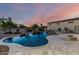 Backyard featuring an in-ground pool with a rock waterfall feature and outdoor firepit at 14494 W Yucatan St, Surprise, AZ 85379