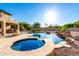 Beautiful backyard pool with spa, rock features, and lush landscaping at 14494 W Yucatan St, Surprise, AZ 85379