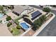 An aerial view showcasing the backyard pool, well-kept lawn, and solar panels on the home at 14676 W Banff Ln, Surprise, AZ 85379