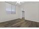 Bedroom with hardwood flooring, a window with blinds, and a walk-in closet at 14676 W Banff Ln, Surprise, AZ 85379