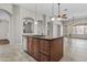 Kitchen island featuring a sink and drawers, seamlessly connecting to a bright living area at 14676 W Banff Ln, Surprise, AZ 85379