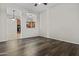 Open living room with hardwood floors and view into the kitchen at 14676 W Banff Ln, Surprise, AZ 85379