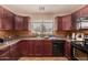 Well-lit kitchen featuring dark wood cabinets, tile backsplash, and stainless steel sink at 1507 W Mesquite Ave, Apache Junction, AZ 85120