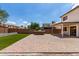 Spacious backyard featuring a stone grill, brick patio, manicured grass, and a covered porch area for outdoor entertaining at 1632 E Leslie Ave, San Tan Valley, AZ 85140