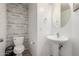 Bathroom features a decorative accent wall, pedestal sink, and round mirror at 1632 E Leslie Ave, San Tan Valley, AZ 85140