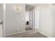 A hallway with neutral walls and carpet leads to rooms, illuminated by a sconce at 1632 E Leslie Ave, San Tan Valley, AZ 85140