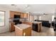 Open kitchen with dark appliances, wood cabinets, mosaic backsplash and an island at 1632 E Leslie Ave, San Tan Valley, AZ 85140