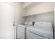 Laundry room with a white washer and dryer, plus shelving at 1632 E Leslie Ave, San Tan Valley, AZ 85140