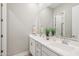 Bathroom featuring double sinks, a large mirror, white cabinets, and neutral decor at 1865 N 141St Ave, Goodyear, AZ 85395