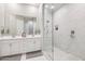 Elegant bathroom featuring double sinks, a large mirror, and a walk-in shower with marble tile at 1865 N 141St Ave, Goodyear, AZ 85395