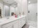 Elegant bathroom featuring double sinks, a large mirror, and a walk-in shower with marble tile at 1865 N 141St Ave, Goodyear, AZ 85395
