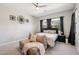 Cozy bedroom with neutral tones, a ceiling fan, and a comfortable seating area at 1865 N 141St Ave, Goodyear, AZ 85395