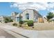 Lovely one-story home showcasing well-maintained landscaping, desert rock, and a blue two car garage door at 1865 N 141St Ave, Goodyear, AZ 85395
