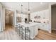 Bright, white kitchen with modern appliances, a large island with seating, and wood-look floors at 1865 N 141St Ave, Goodyear, AZ 85395