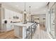 Stylish white kitchen with a center island and bar seating, flowing into dining and living areas at 1865 N 141St Ave, Goodyear, AZ 85395