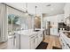 Bright kitchen boasts white cabinets, a center island with seating, and stainless steel appliances at 1865 N 141St Ave, Goodyear, AZ 85395