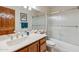 Bright bathroom featuring a vanity, framed mirror, framed art, and shower over tub with glass door at 18851 N 69Th Ave, Glendale, AZ 85308