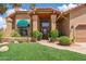Inviting front entrance with desert landscaping, brick walkway and covered porch with wooden detailing at 18851 N 69Th Ave, Glendale, AZ 85308