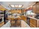 Expansive kitchen featuring plentiful wooden cabinetry, an island with seating, and modern appliances at 18851 N 69Th Ave, Glendale, AZ 85308