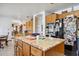 Kitchen island featuring wooden cabinetry, marble countertops, and modern stainless steel appliances at 18851 N 69Th Ave, Glendale, AZ 85308