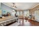 Bright primary bedroom with hardwood floors, a ceiling fan, and large windows at 18851 N 69Th Ave, Glendale, AZ 85308