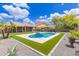 Beautiful backyard with a swimming pool, green lawn, and lush landscaping at 2111 E Yellowstone Pl, Chandler, AZ 85249