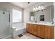 Bathroom featuring a double vanity, a large mirror, and a shower-tub combo at 2111 E Yellowstone Pl, Chandler, AZ 85249