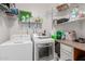 Functional laundry room with a washer, dryer, storage shelves and counter space at 2111 E Yellowstone Pl, Chandler, AZ 85249