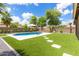 Outdoor pool area with a lush lawn, mature landscaping, and umbrella at 2111 E Yellowstone Pl, Chandler, AZ 85249