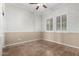 Bedroom featuring decorative wall paint, tile flooring, white ceiling fan, and plantation shutters at 22222 N Pedregosa Dr, Sun City West, AZ 85375