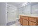 Bright bathroom featuring a glass shower, wood cabinets, and tile flooring at 2505 E Desert Cactus St, Phoenix, AZ 85032