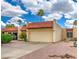 Charming home featuring a two-car garage, terra cotta roof, desert landscaping, and mature palm trees at 2505 E Desert Cactus St, Phoenix, AZ 85032