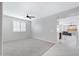 Bright bedroom with plush carpet, a ceiling fan, and an abundance of natural light from large windows at 25974 W Horsham Dr, Buckeye, AZ 85396