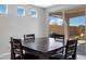 Bright dining room features a dark wood table, backyard access and three modern, above-counter windows at 25974 W Horsham Dr, Buckeye, AZ 85396