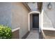 Close-up view of the inviting front entrance with dark wooden door and manicured shrubs at 25974 W Horsham Dr, Buckeye, AZ 85396