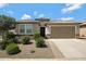 Charming single-story home featuring a desert landscape, a two-car garage, and a stylish tiled roof at 25974 W Horsham Dr, Buckeye, AZ 85396