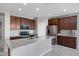 Spacious kitchen features stainless steel appliances, dark wood cabinetry, granite countertops, and large center island at 25974 W Horsham Dr, Buckeye, AZ 85396
