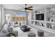 Bright living room features large windows, comfortable seating, ceiling fan, and built-in shelving around the television at 25974 W Horsham Dr, Buckeye, AZ 85396