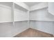 Empty walk-in closet with carpet flooring, bright neutral paint and built-in metal shelving at 25974 W Horsham Dr, Buckeye, AZ 85396