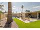 Expansive backyard with a pool, patio area, artificial grass, and charming string lights for evening ambiance at 2611 E Cheryl Dr, Phoenix, AZ 85028