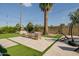 Landscaped backyard with an artificial lawn, palm trees, patio furniture, and string lights for outdoor relaxation at 2611 E Cheryl Dr, Phoenix, AZ 85028