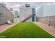 Large backyard with artificial turf, a patio, and access to an upper level via exterior stairs at 2731 E Windsor Ave, Phoenix, AZ 85008