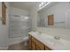Bathroom with dual sinks, framed mirror, glass-enclosed tub and tiled floors at 29058 N Cactus Cir, San Tan Valley, AZ 85143