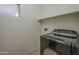 A room featuring a black washing machine and a small window at 29058 N Cactus Cir, San Tan Valley, AZ 85143