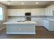 Modern kitchen featuring white cabinets, quartz countertops, and stainless steel appliances at 31866 N Bandit Rd, San Tan Valley, AZ 85143