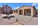 This backyard boasts gravel landscaping, a small tree, desert landscaping, and a covered patio at 36255 W Marin Ave, Maricopa, AZ 85138